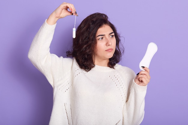 Pensativa mujer de pelo oscuro con camisa blanca