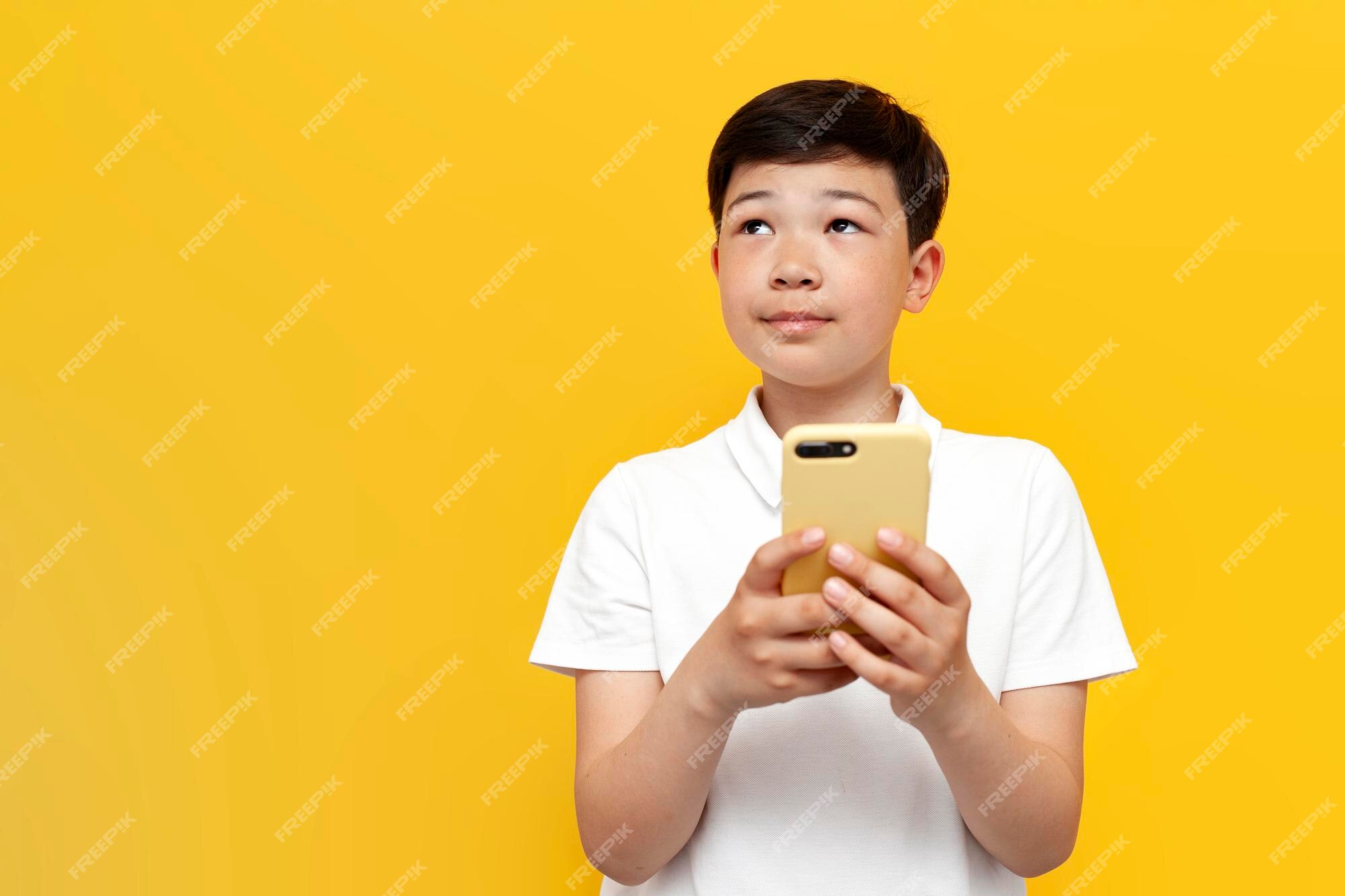 Menino Tailandês Asiático Do Preteen Que Usa Um Smartphone Para