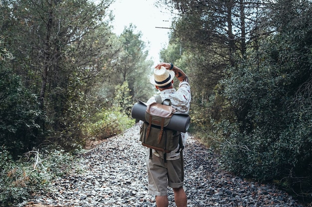 Pensativo viajante de costas para a câmera olhando para o horizonte da estrada