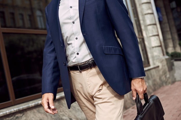 Foto pense em uma reunião de negócios com um homem elegante em um terno casual sorrindo enquanto caminha ao ar livre