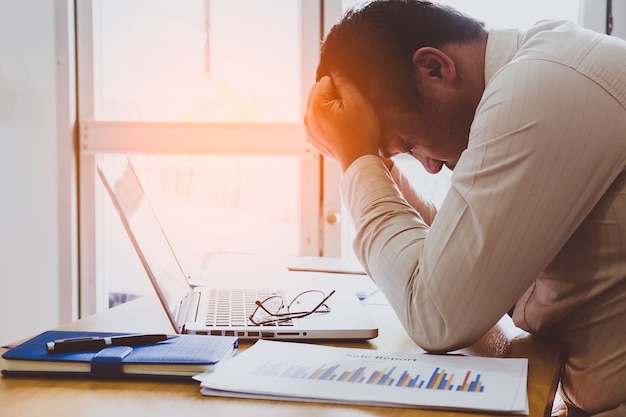 Foto pense forte na análise no trabalho. jovem empresário forçado no escritório