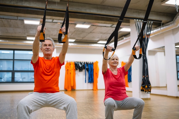 Foto pensioniertes paartraining mit fangen turnhalle ein