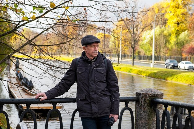 Un pensionista anciano se encuentra en un hermoso día de otoño en el parque de la ciudad y descansa durante la caminata Enfoque selectivo