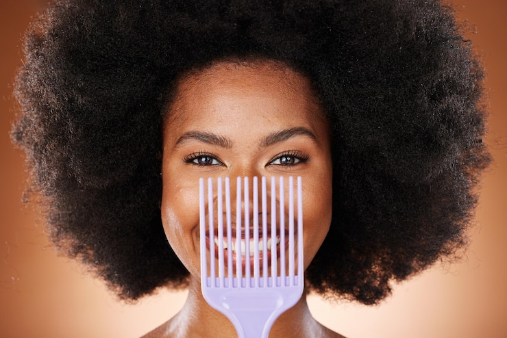 Foto pente de cuidado de cabelo e mulher negra com beleza natural de sorriso e cuidados com a pele contra fundo de estúdio marrom esteticista de cosméticos e mulher afro-americana com penteado afro e feliz com retrato