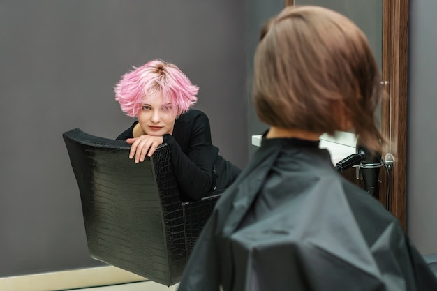 Penteado bonito de jovem depois de morrer o cabelo, outra mulher está fazendo o cabelo