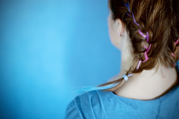 Penteado de menina geração z em cabelo colorido de fundo azul