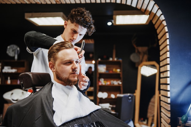 Penteado e corte de cabelo masculino em uma barbearia ou salão de cabeleireiro.