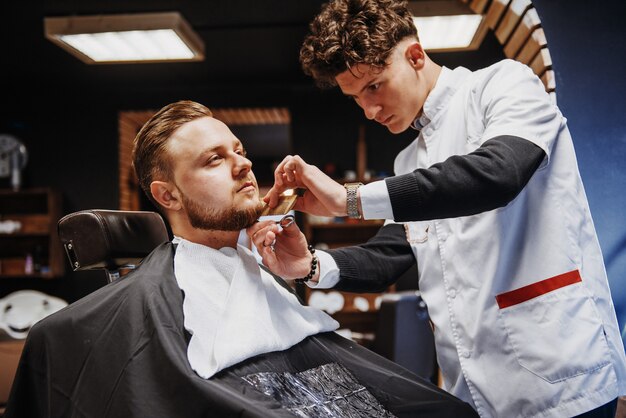 Penteado e corte de cabelo masculino em uma barbearia ou salão de cabeleireiro.