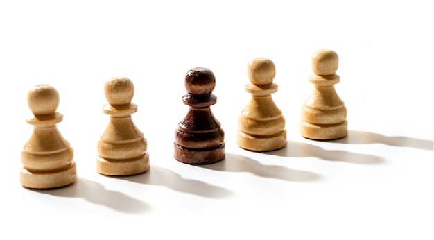 Un peón de ajedrez negro entre los blancos. Concepto de racismo y discriminación.