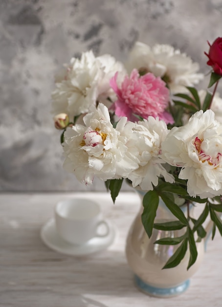 peônias brancas e rosa em um vaso branco