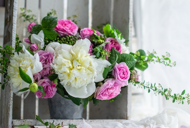 Peônias e rosas em um vaso