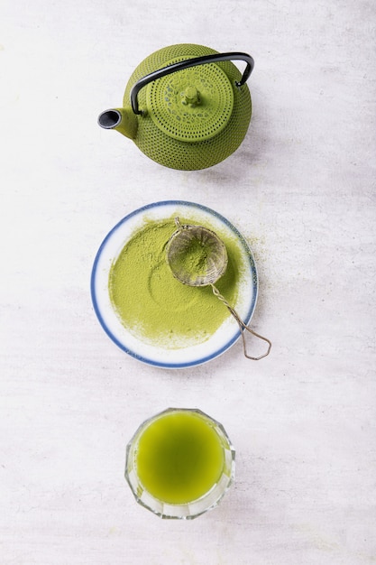 Foto peparación de té matcha: varios utensilios de té matcha sobre una madera gris, vista superior