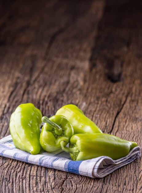 Peper verde. toalha de mesa quadriculada azul de pimenta verde fresca na velha mesa de carvalho.