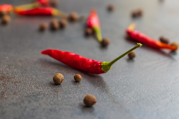 Foto peperoni mit gewürzen auf holztisch hautnah