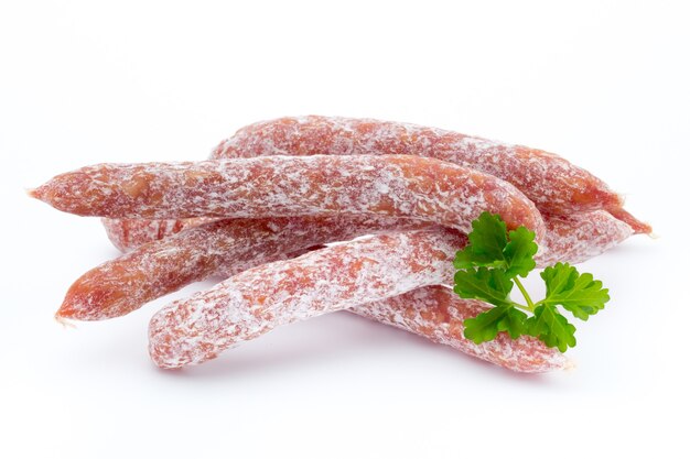 Peperoni ou salame ao estilo suíço, salsinha. Isolado na superfície branca.