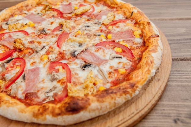 Peperoni-Pizza mit Mozzarella-Käse, Schinken, Tomaten, Paprika, Gewürzen . Italienische Pizza.