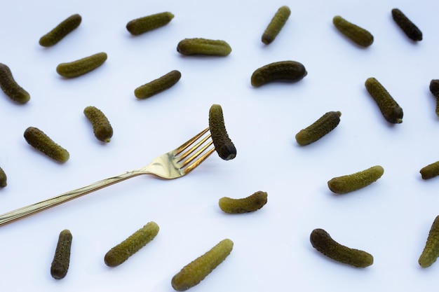 Pepinillos o pepinos en escabeche sobre fondo blanco.