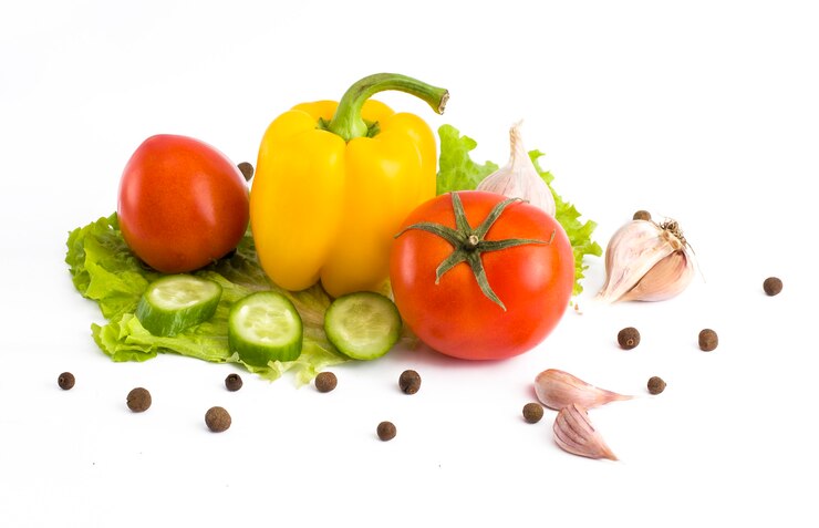 Pepino com tomate e pimenta em um fundo branco. Legumes em um fundo branco. Legumes frescos multicoloridos em um fundo branco.