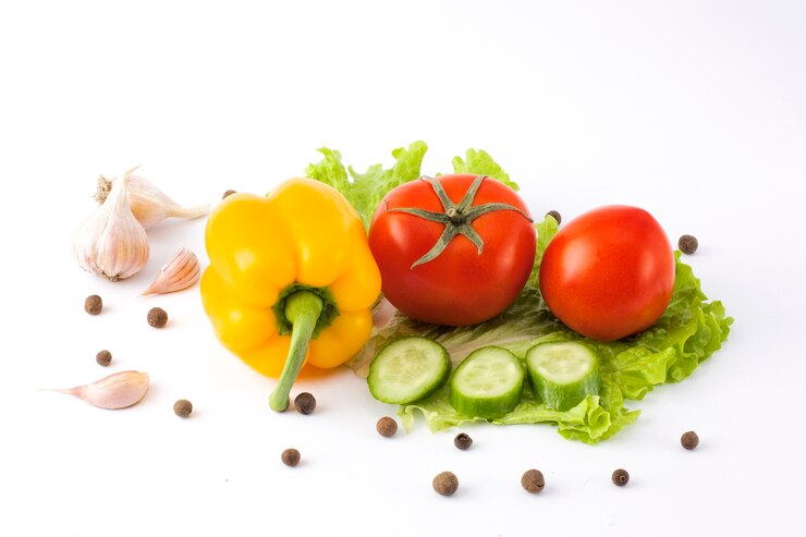 Pepino com tomate e pimenta em um fundo branco. Legumes em um fundo branco. Legumes frescos multicoloridos em um fundo branco.