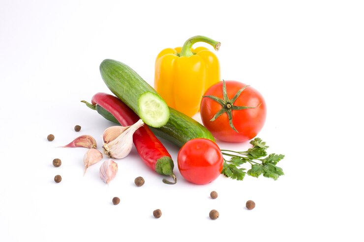 Pepino com tomate e pimenta em um fundo branco. Legumes em um fundo branco. Legumes frescos multicoloridos em um fundo branco.