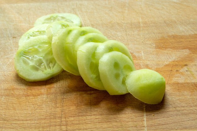 Foto pepino descascado e fatiado em uma tábua de madeira de perto