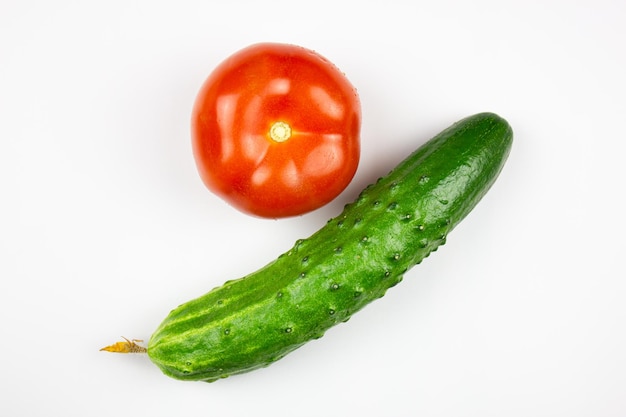 Pepino e tomate closeup em um fundo branco isolado Legumes maduros naturais tomate orgânico e pepino