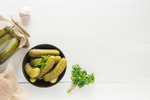 Pepino enlatado en frascos de vidrio y en un tazón