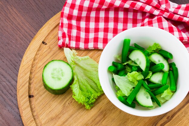 Pepino y ensalada en una tabla de cortar