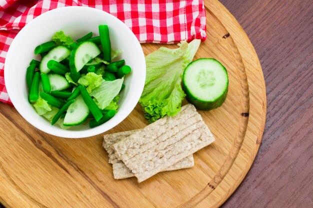 Pepino y ensalada en una tabla de cortar