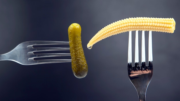 Pepino en escabeche y maíz en un primer plano de la horquilla