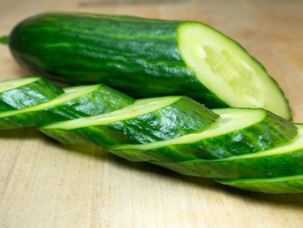 Un pepino liso de tamaño mediano cortado en rodajas Pepino en una tabla de cortar Vegetal aislado Vegetal fresco maduro