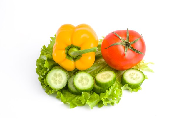 Pepino con tomate y pimiento sobre un fondo blanco. Verduras sobre un fondo blanco. Verduras frescas multicolores sobre un fondo blanco.