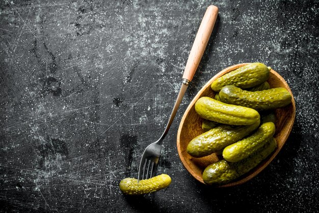 Pepinos en conserva en un plato con un pepino en un tenedor