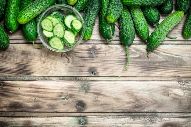 Pepinos e fatias de pepino em uma tigela de vidro