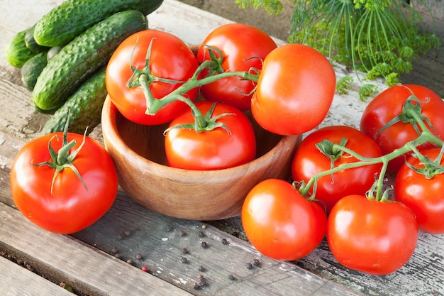 Pepinos e tomates na prancha de madeira