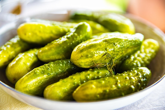 Foto pepinos encurtidos con hierbas y especias en un plato blanco pepinos marinados caseros con especias