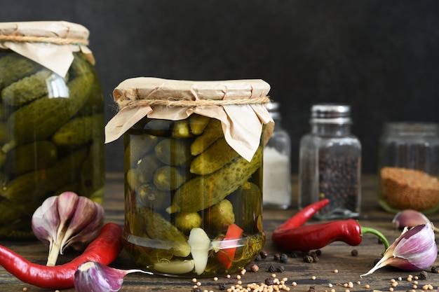 Foto pepinos en escabeche con eneldo y ajo en un frasco de vidrio.