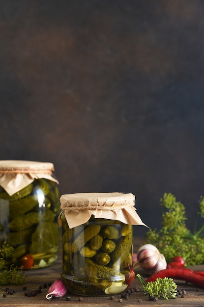 Foto pepinos en escabeche con eneldo y ajo en un frasco de vidrio.