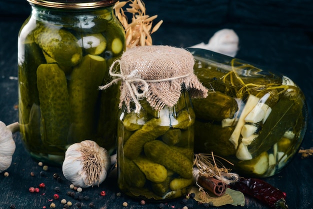 Pepinos en escabeche en un frasco Existencias de alimentos Vista superior Sobre un fondo de madera Espacio de copia