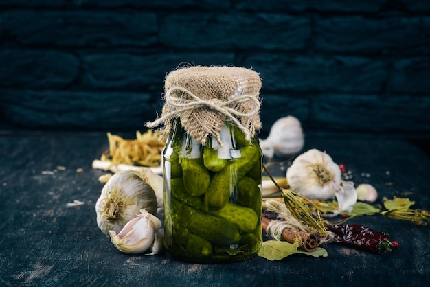 Pepinos en escabeche en un frasco Existencias de alimentos Vista superior Sobre un fondo de madera Espacio de copia