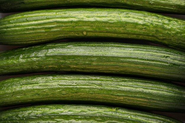 Pepinos frescos e foto macro do fundo com textura verde.