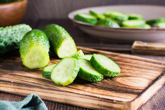 Pepinos frescos en rodajas en una tabla de cortar sobre la mesa Alimentos dietéticos orgánicos