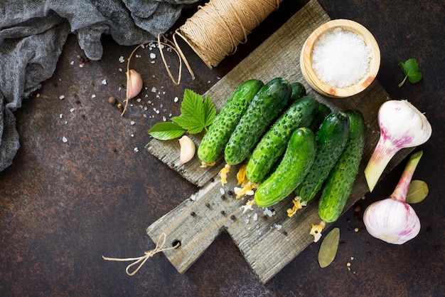 Pepinos maduros con hierbas sobre tabla de madera