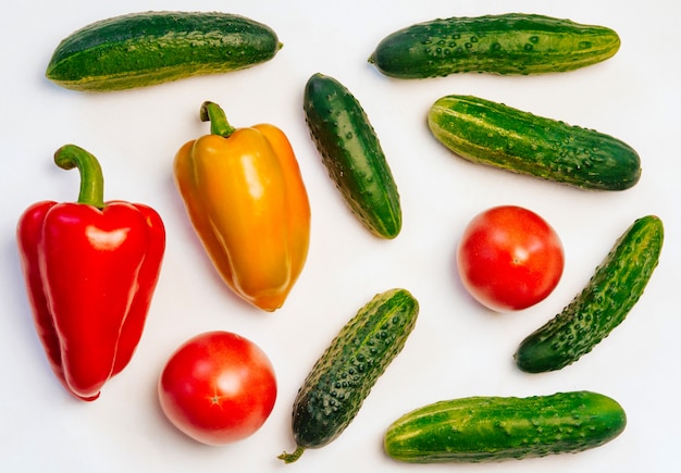 Pepinos, tomates e pimentos em branco