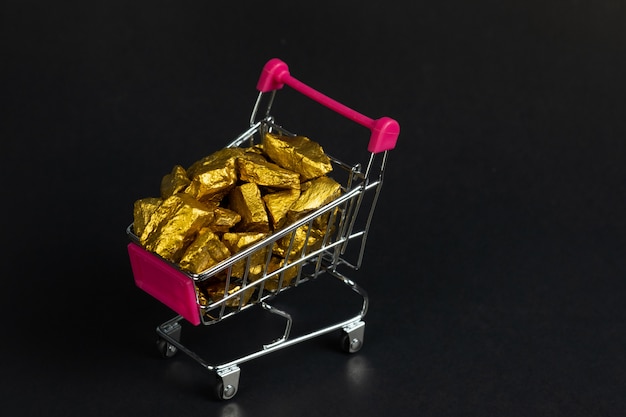 pepitas de ouro ou minério de ouro no carrinho de compras ou carrinho de supermercado