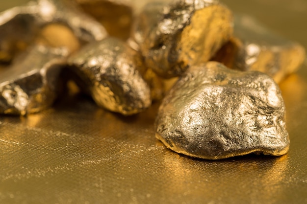 Foto pepitas de oro sobre un fondo dorado