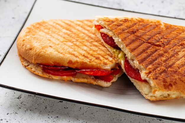 Pepperoni panini fresco a la parrilla sobre un fondo claro