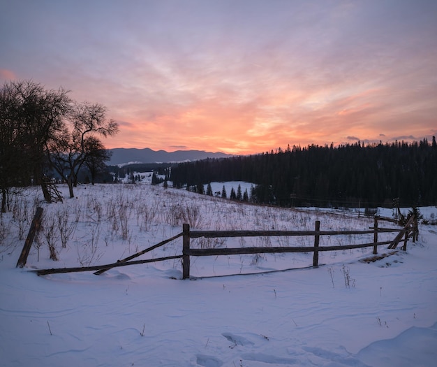 Pequena aldeia alpina e montanhas nevadas de inverno na primeira luz do sol ao nascer do sol em torno de voronenko carpathian ucrânia