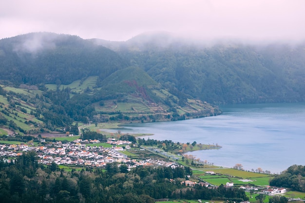 Pequena aldeia com belas casas perto de uma floresta e um lago