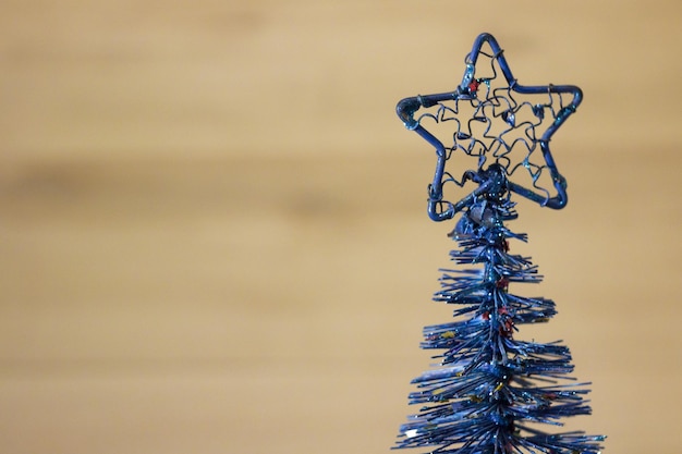Pequena árvore de Natal azul artificial de Natal em um fundo marrom